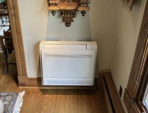 Floor-mounted air conditioning unit in a period room with timber panelling